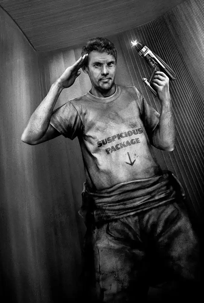 A grim, dirt-smudged man in a t-shirt reading SUSPICIOUS PACKAGE raises a flashlight and holds a mock salute inside a cramped metal room.